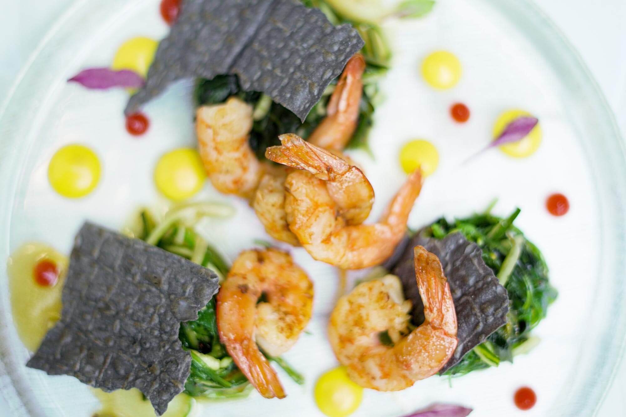 Shrimps with seaweed salad and passion fruit purée with coconut milk and curry